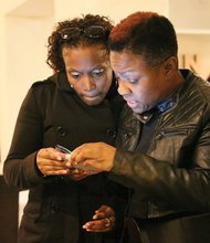 Radio personality “Miss Community” Clovia Lawrence, right, and Ebony Leach peruse poll results Tuesday night at an election night gathering at Southern Kitchen in Shockoe Bottom. 
