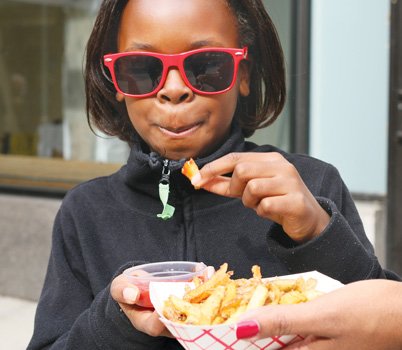 Adilrah Johnson, 8 enjoys fries at Graze on Grace as her mom Shoshana Johnson holds them for her.  