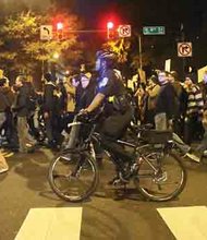 Hundreds of Richmonders took to the streets Monday and Tuesday night protesting a Missouri grand jury’s decision to reject charges against the police officer involved in the slaying of teenager Michael Brown Jr. in a St. Louis suburb. A police officer accompanies throngs of young people marching Tuesday near City Hall in Downtown following a rally.