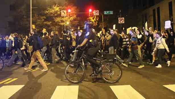 Hundreds of Richmonders took to the streets Monday and Tuesday night protesting a Missouri grand jury’s decision to reject charges against the police officer involved in the slaying of teenager Michael Brown Jr. in a St. Louis suburb. A police officer accompanies throngs of young people marching Tuesday near City Hall in Downtown following a rally.