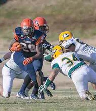 Virginia State University running back Kavon Bellamy pushes past Long Island University-Post defenders Saturday in Ettrick. The Trojans won, 28-17, moving to the second round in the NCAA playoffs.