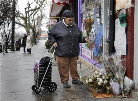 
A woman, who did not want to give her name, places flowers at a memorial for Eric Garner near the site of his death in the borough of Staten Island Wednesday, Dec. 3, 2014., in New York. A grand jury is deciding whether to indict a New York City police officer in the chokehold death of Garner. (AP Photo/Seth Wenig)
