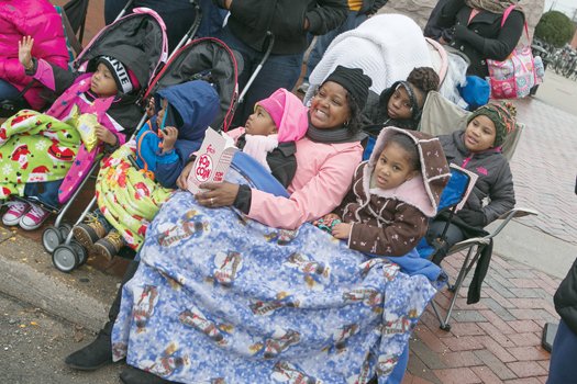 Parade-goers stay warm as they enjoy the array of floats, marching bands and even an appearance by Santa Claus.