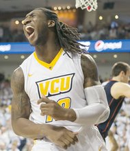 VCU’s Mo Alie-Cox reacts after dunking the ball against the University of Virginia during last Saturday’s game.
