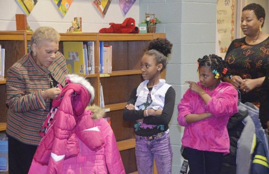 Gwen Drayton, left, co-chairwoman of the Richmond Continentals’ Gift of Warmth Committee, checks sizes before handing out coats Dec. 3 at Blackwell Elementary School on South Side. The Continentals gave out 300 coats at several city schools this year.