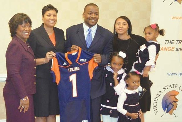 New Virginia State University football coach Byron Thweatt is flanked from left by VSU interim President Pamela V. Hammond; Athletic Director Peggy Davis; his wife, Mieya; and their three daughters, 2-year-old Bralynn (being held), 7-year-old Brianna and 4-year-old Bryce.