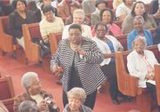 The Rev. Carolyn Clark dramatically presents a soul-stirring song at the Citywide Mass Meeting at Cedar Street Baptist Church of God.