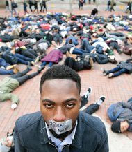 University of Michigan student William Royster stands with the “#Black Lives Matter” message taped over his mouth as he is surrounded by students at the Ann Arbor, Mich., university staging a recent “die-in” protesting the killing of unarmed black men by white police officers.