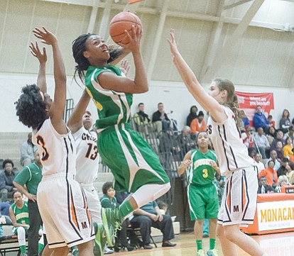 Huguenot High School star sophomore guard Taya Robinson slices through three Monacan defenders en route to the basket in a recent game.