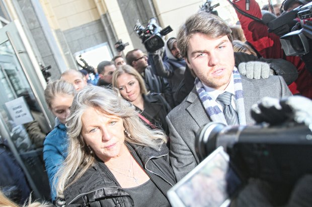Maureen McDonnell walks through a bevy of media as she leaves the federal courthouse in Downtown with her son, Bobby, and daughter, Rachel, after her sentencing last Friday