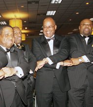 members of the Beta Gamma Lambda Chapter of Alpha Phi Alpha Fraternity clasp hands as
they are about to sing their fraternity song Saturday night at the organization’s 2015 Black and Gold Ball at
a Richmond area hotel.