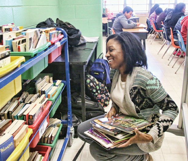 Teacher Cierra Claughton selects books for her seventh- grade English class at Clark Springs Elementary School Wednesday. She and other teachers, administrators and students made the transition this week into the West End elementary school after they were forced to move from Elkhardt Middle School in South Side because of a mold infestation.