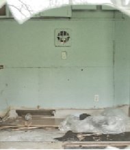 A view through a trailer’s broken window shows the destruction inside.