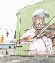 Local artist Ed Trask wants his mural in the 1100 block of North 25th Street in Church Hill to say, “Hey, look at this area. These lovely people are not getting the same chances the rest of us are receiving.” Mr. Trask said he painted the mural, on his own time, to splash some color into the bleak landscape of the impoverished neighborhood. He wanted kids in the city’s East End to know that the city loves them and to give the residents in “sometimes forgotten certain areas ... a new sense of optimism through color and light.” The mural was completed with help from local businesses and organizations, such as the Better Block initiative, a community effort to improve the safety and appeal of local neighborhoods. Mr. Trask said he hopes the mural will get people to see the area in a different light.