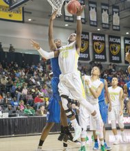 Henrico High School junior Monte Buckingham flies high to the basket in the Warriors’ 78-64 win over Norfolk’s Norview High School in the 5A state championship
game at the Siegel Center.