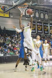Henrico High School junior Monte Buckingham flies high to the basket in the Warriors’ 78-64 win over Norfolk’s Norview High School in the 5A state championship
game at the Siegel Center.