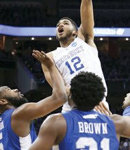 University of Kentucky forward Karl-Anthony Towns shoots over a trio of Hampton University defenders last Thursday in the No. 1 seed Wildcats’ 79-56 rout of the 
No. 16 seed Pirates in the second round of the NCAA Tournament.