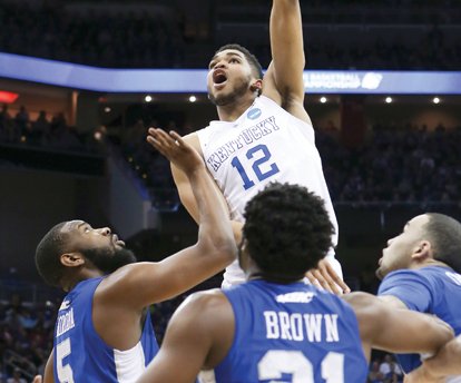 University of Kentucky forward Karl-Anthony Towns shoots over a trio of Hampton University defenders last Thursday in the No. 1 seed Wildcats’ 79-56 rout of the 
No. 16 seed Pirates in the second round of the NCAA Tournament.