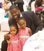 Robert W. Brown Jr. shares a treasured moment Sunday with his daughters, Kendell, 2, and Morgan, 4, at the Trinity Family Life Center on North Side.