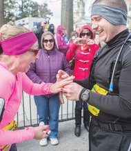 Shocked, but obviously delighted, she can’t contain her excitement as he slides the engagement ring on her finger as onlookers watch and capture the moment on their cell phones.