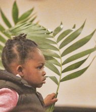Nyjah Caleb, 2, holds a palm frond at East End Fellowship’s Palm Sunday worship service in Church Hill. She and others waved their palms to symbolize the palm branches the crowd scattered in front of Jesus as he rode into Jerusalem a few days before his crucifixion and resurrection that Christians will celebrate this weekend.