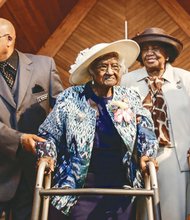 
Jeralean Talley, center, is escorted into New Jerusalem Baptist Church in Inkster, Mich., by Deacon Charles Smith and church charter member Willa Williams during a reception in her honor on May 25, 2014. Mrs. Talley had just turned 115 on May 23.