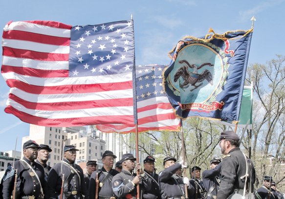 Re-enactors representing the United States Colored Troops triumphantly march Saturday along Bank Street.