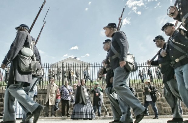 Re-enactors representing the United States Colored Troops triumphantly march Saturday along Bank Street.