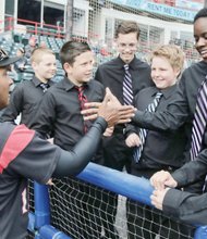 Richmond Flying Squirrels manager José Alguacil enthusiastically greets Bryce Hendriksen, a member of the Tomahawk Creek Middle School Boys Choir at The Diamond as other choir members look on. The team then took the field Wednesday to play the Altoona Curve on “Jackie Robinson Day,” its annual tribute to the trailblazing infielder who broke the color barrier by becoming the first African-American to play for a major league team. Mr. Robinson suited up for the Brooklyn Dodgers on April 15, 1947. Please turn to B10 for additional coverage.