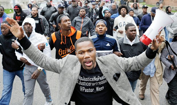 The Rev. Westly West leads demonstrators to the Baltimore Police Department’s Western District police station Wednesday to protest the death of Freddie Gray while in police custody.