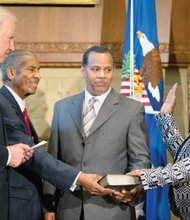 
Loretta Lynch is sworn in Monday by Vice President Joe Biden, left, as the new U.S. attorney general in a ceremony at the Justice Department. Her father, Lorenzo Lynch, second from left, and husband, Stephen Hargrove, proudly hold the Bible.