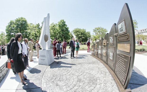 Virginia Union University President Claude G. Perkins and his wife, Cheryl, center, view a monument unveiled Wednesday to mark VUU’s 150th anniversary. Sculptor Ed Dwight of Denver spoke at the ceremony. One part of the monument tells VUU’s history, while the other portion contains the university’s insignia, along with the inscribed names of Dr. Perkins, trustee board members and honorary trustees.