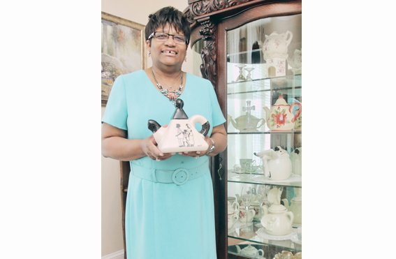 The Rev. Jeanette Brown displays one of the more than 100 colorful teapots at Harriet’s Place, the North Side home of Scripture Tea Fellowship Ministries.