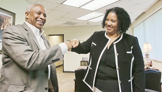 Shunda T. Giles, the new director of the Richmond Department of Social Services, exchanges a fist bump Monday with her predecessor, David M. Hicks. Mr. Hicks becomes a Richmond General District Court judge on July 1.