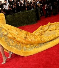 Rihanna  arrives at the Met Gala in a stunning yellow coat obviously designed for royalty.