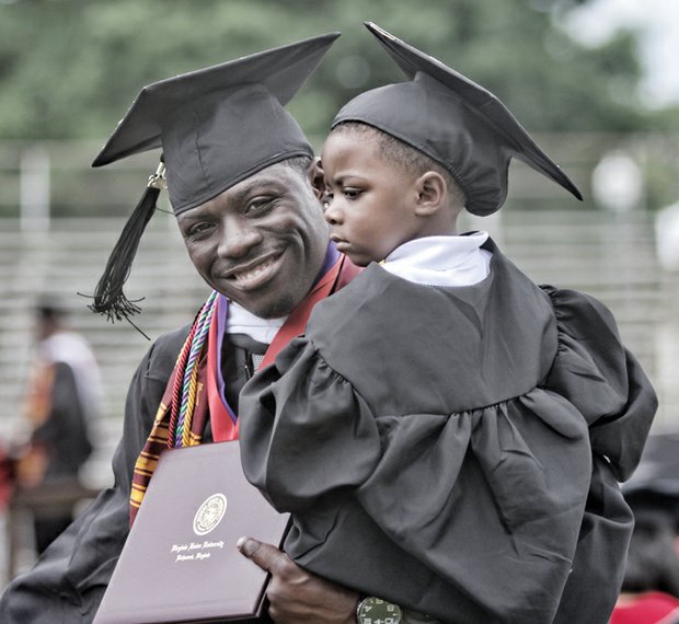 Like father, like son.  Justin White holds two of his proud accomplishments — his son, Jeremiah, and his newly earned degree from Virginia Union University. The father and son celebrated in cap and gown Saturday at the university’s 117th commencement ceremony at Hovey Field.