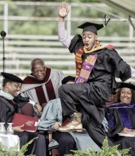 A happy Virginia Union University graduate and member of Omega Psi Phi Fraternity gives a celebratory stomp as he heads across the stage to collect his new degree.