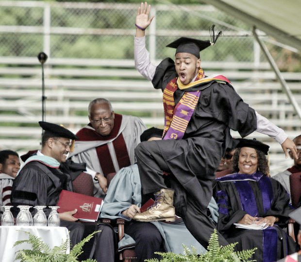 A happy Virginia Union University graduate and member of Omega Psi Phi Fraternity gives a celebratory stomp as he heads across the stage to collect his new degree.