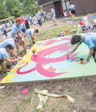 Volunteers paint a colorful mural at a new playground they built May 7 at Elizabeth D. Redd Elementary School on South Side to honor the memory of Martin “Marty” Cobb, who was a first-grader at the school.