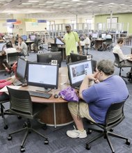 Main Library patrons work intently on computers on the second floor. The library now has 95 computers available to serve the public.