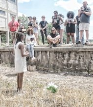 Darlene Scott, one of the event organizers, addresses the group after the Confederate flag was buried in a symbolic funeral Monday at Intermediate Terminal near the James River.