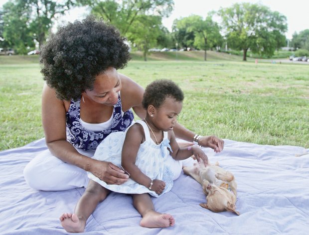 Bernadette Miller and her granddaughter, Dekea Williams, shower affection for their Chihuahua, Peanut.