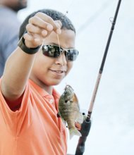 Melvin Oliver, 11, shows off the bluegill he caught Saturday in Shields Lake during the Family Fishing Fair in Byrd Park