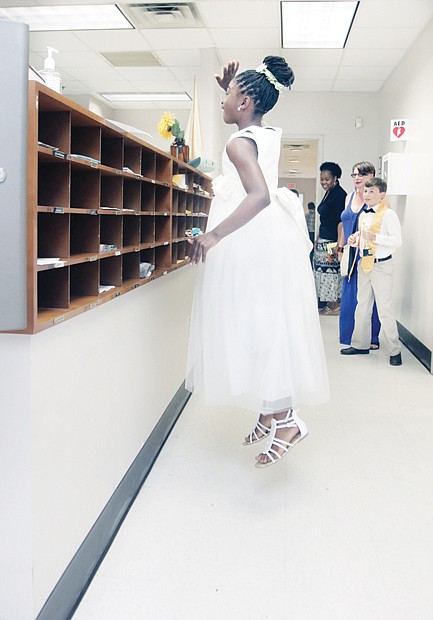 Uplifting last day
A smiling Aniyah Rajab, 11, attracts attention as she jumps to wave goodbye to office staff at Linwood Holton Elementary School last Friday — the final day of public school classes in Richmond. All dressed up and ready to go, the fifth-grader, who will head to middle school this fall, was among the more than 23,000 city students who streamed out school doors into summer vacation. 