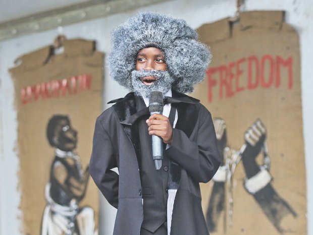 JUNETEENTH- Scores of people gathered on South Side last Saturday to celebrate Juneteenth, the day that commemorates the announcement of the abolition of slavery in Texas on June 19, 1865. Right, Elijah Coles Brown, a gifted 11-year-old orator from Henrico County who donned a wig, beard and period dress, recites Frederick Douglass’ famed “The Meaning of July Fourth for the Negro” speech. The speech attacked the hypocrisy of July 4th celebrations during times of enslavement. 