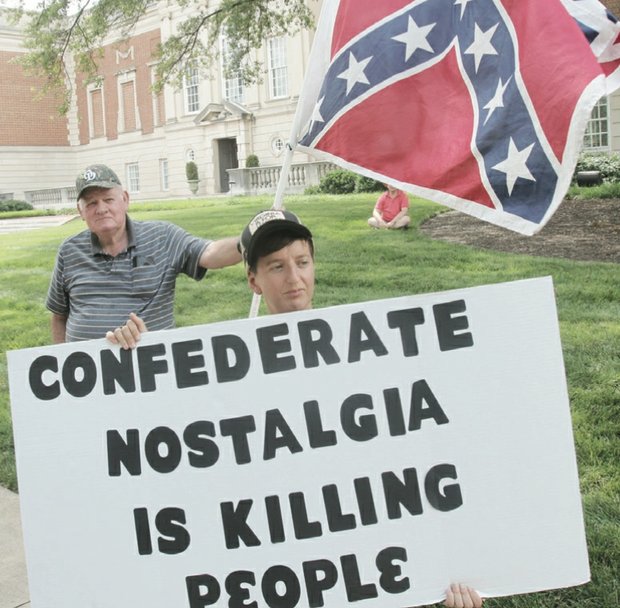 
Sydney Lester of the Virginia Flaggers carries the Confederate battle flag during his group’s protest last Saturday in front of the Virginia Museum of Fine Arts on the Boulevard. The museum has removed the symbol of hate from the Confederate Chapel located behind the museum. When the Virginia Flaggers were spotted, Camille Rudney and members of Justice 4 RVA arrived with their own signs in solidarity with Charleston, S.C., calling for the flag to be put away.