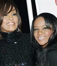 In this Feb. 12, 2011, file photo, singer Whitney Houston, left, and daughter Bobbi Kristina Brown arrive at an event in Beverly Hills, Calif. Brown is moving to hospice care after months of receiving medical care. Pat Houston says in a statement Wednesday, June 24, 2015, that Whitney Houston’s daughter’s “condition has continued to deteriorate. Brown was found face-down and unresponsive in a bathtub of her Georgia home earlier this year. She underwent surgery to replace her breathing tube with a tracheostomy tube in February.