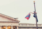 Bree Newsome boldly holds the Confederate flag after climbing the flagpole at the Statehouse in Columbia, S.C., to take it down last Saturday.