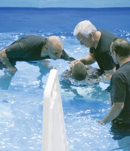 Wayne Rhodes, James Haney and James Rhodes perform a baptism ceremony. 