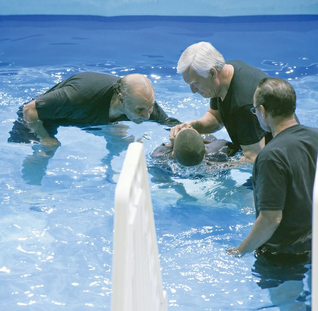 Wayne Rhodes, James Haney and James Rhodes perform a baptism ceremony. 
